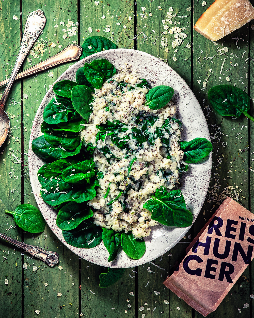 Parmesan Spinat Porige auf Steinteller vor grünem Hintergrund